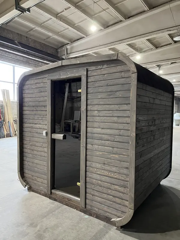Façade avant d’un sauna cube 2 m gris foncé, porte vitrée centrale et petite fenêtre.