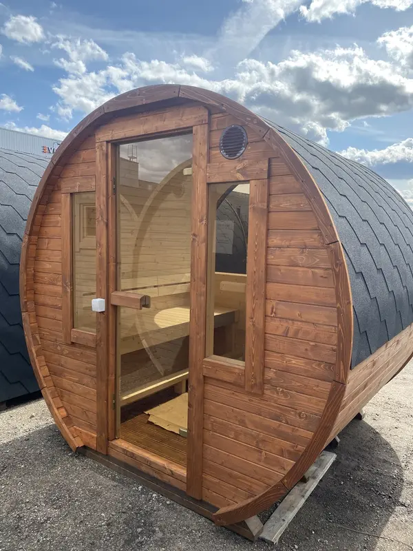 Sauna tonneau en bois naturel vu de l’entrée, intérieur visible