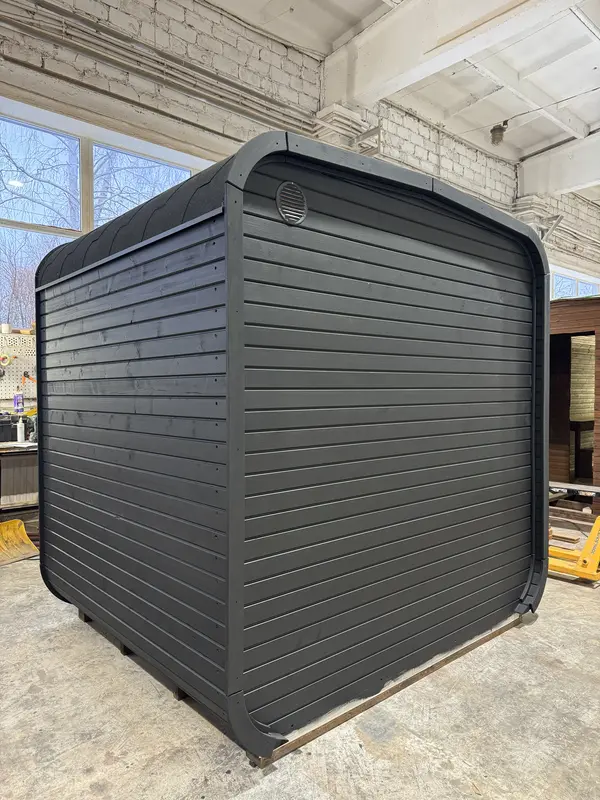 Sauna cube 2 m peint en noir mat, vue d’angle montrant les parois latérales ajourées et le toit arrondi