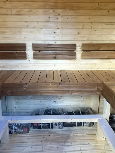 Banquettes intérieures d’un sauna cube 2 m, avec éclairage LED sous l’assise et mur lambrissé clair.