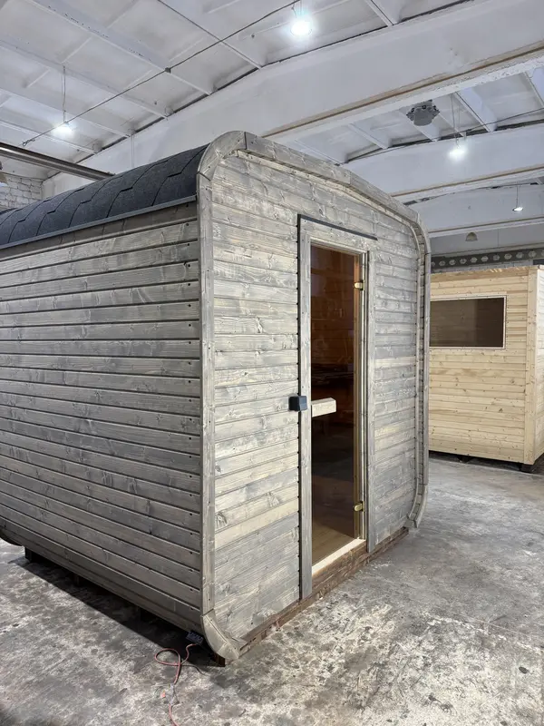 Sauna cube 2 m gris clair, vue d’angle avec porte vitrée centrale et petite fenêtre latérale