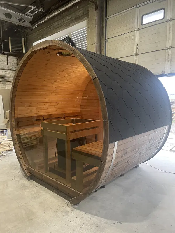 Vue latérale du sauna tonneau avec toit en bardeaux noirs