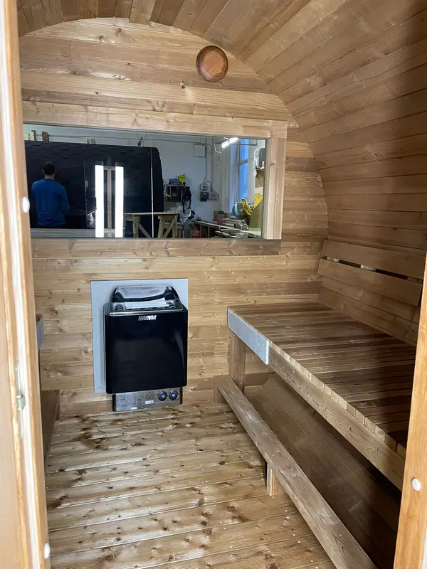 Intérieur du sauna tonneau montrant les supports pour le poêle