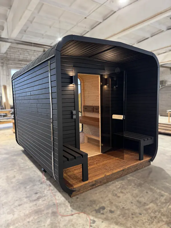 Sauna tonneau 3 m noir, vue avant avec banc d’entrée et encadrement en bois Thermo.