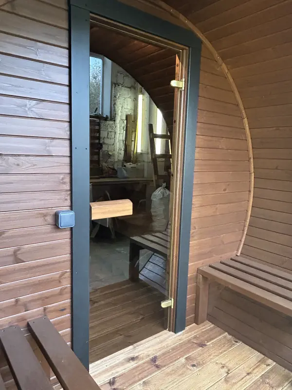 Sauna tonneau 3 m en bois naturel, intérieur visible à travers la porte