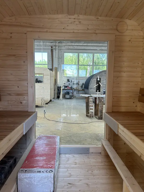 Couloir intérieur d’un sauna cube 3 m, banquettes latérales en bois naturel et mur lambrissé clair.