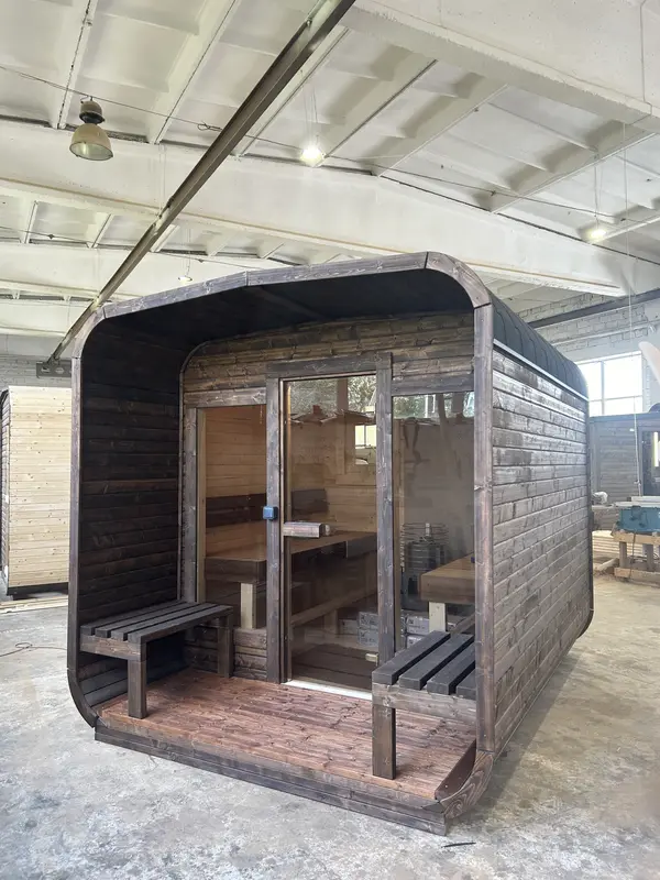 Sauna cube 3 m gris anthracite, angle avant avec porte vitrée et petit banc d’entrée