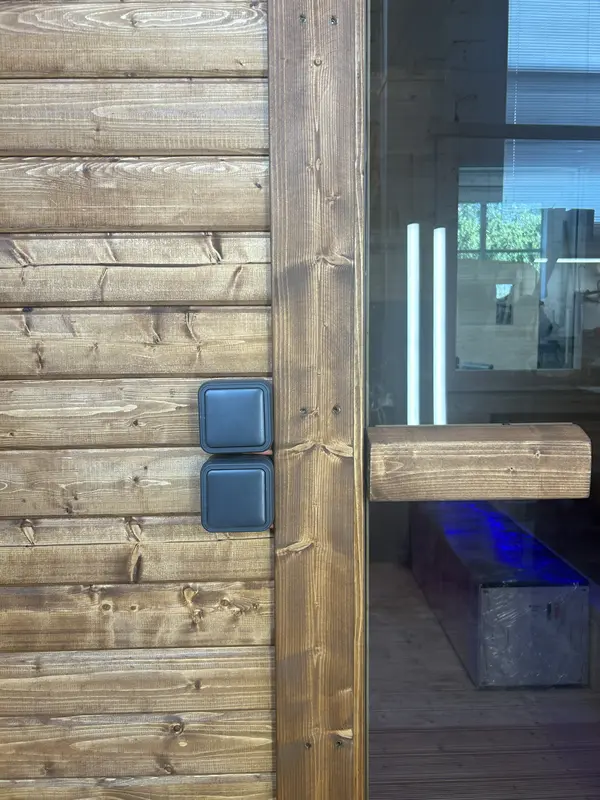 Détail extérieur d’un sauna tonneau montrant les boîtiers électriques et l’angle du bardage ThermoWood.