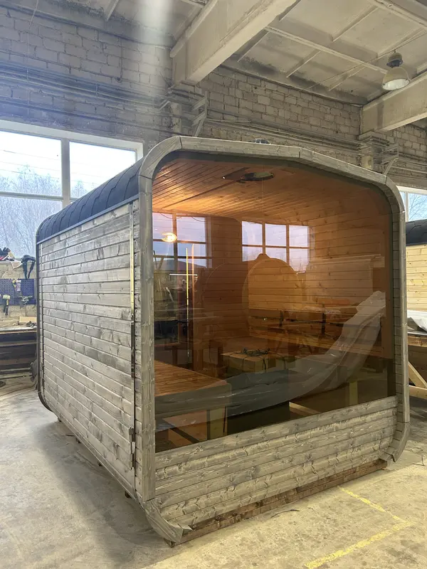 Vue arrière d’un sauna cube 3 m ThermoWood gris, grande fenêtre panoramique et parois lambrissées