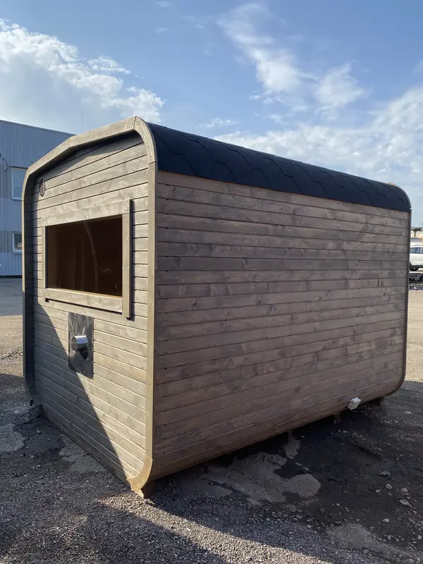 Façade avant d’un sauna cube 3 m Relax brun foncé, porte vitrée et petit banc d’accueil intégré.