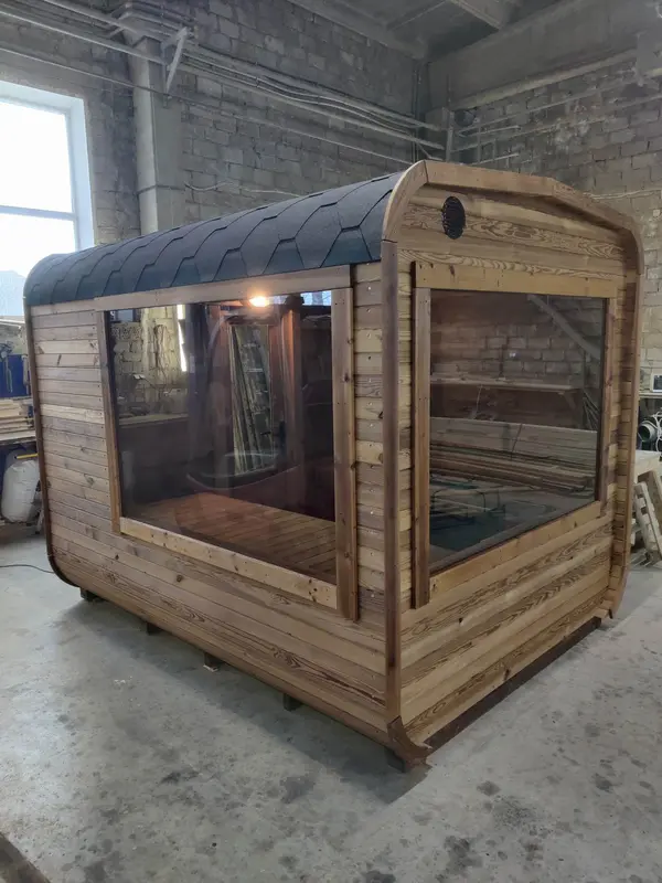 Sauna tonneau 3 m ThermoWood brun, grande baie vitrée panoramique sur la façade latérale.