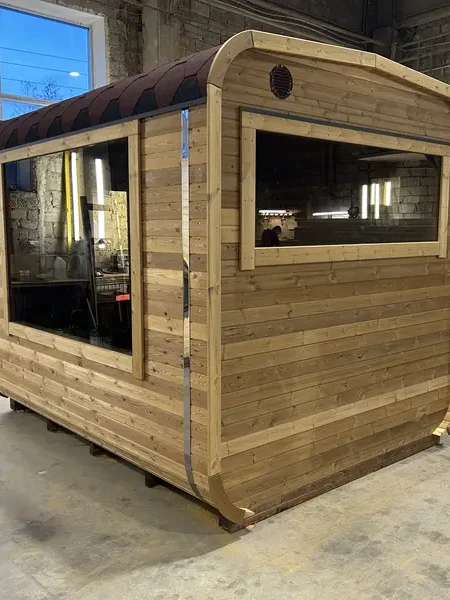 Autre vue d’angle d’un sauna cube 3 m en bois naturel non traité, fenêtre latérale et toit arrondi.
