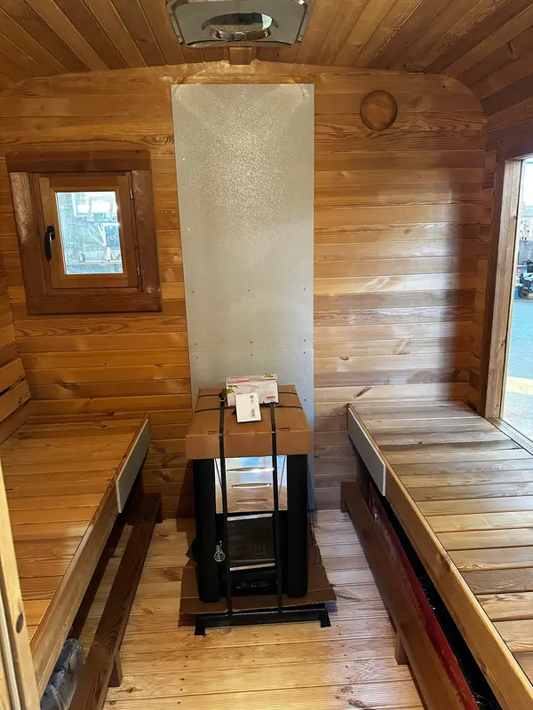 Vue intérieure rapprochée d’un sauna cube 4 m, banquettes en vis-à-vis et parois lambrissées