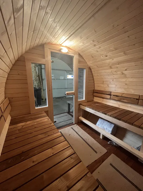 Banquettes en mélèze à l’intérieur du sauna tonneau 4 m, mur latéral en bois clair