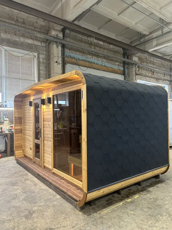 Sauna 4 m large en ThermoWood brun avec toit à motifs écaillés noirs et double porte vitrée.