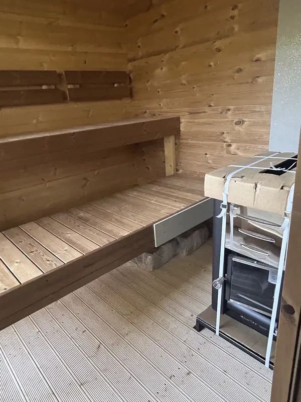 Gros plan sur les banquettes intérieures du sauna 4 m, structure bois naturel et lattes espacées.