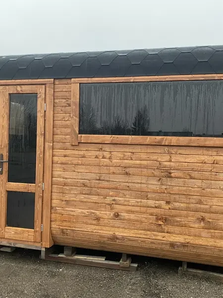 Sauna cube 4 m brun clair, vue latérale avec porte vitrée et petite fenêtre haute.