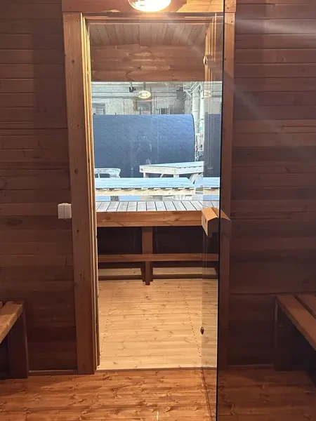 Intérieur d’un sauna cube 4 m montrant un banc à deux niveaux contre un mur lambrissé en bois naturel.