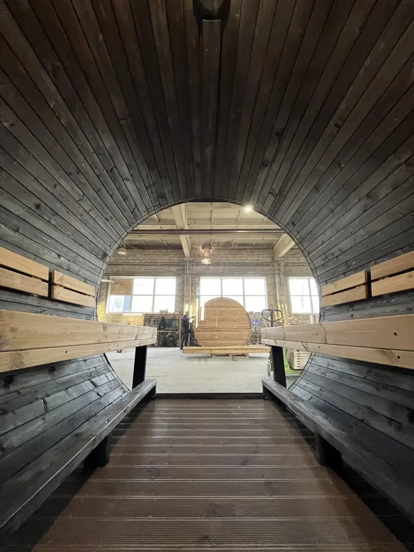 Intérieur du sauna tonneau 4 m peint en noir : banquettes et éclairage discret