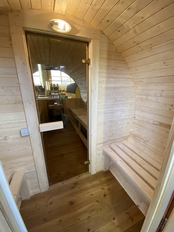 Intérieur du sauna tonneau 5 m Relax, banquette en bois clair le long de la paroi