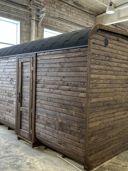 Vue arrière d’un sauna cube 5 m ThermoWood brun, bardage à lames horizontales et toit cintré