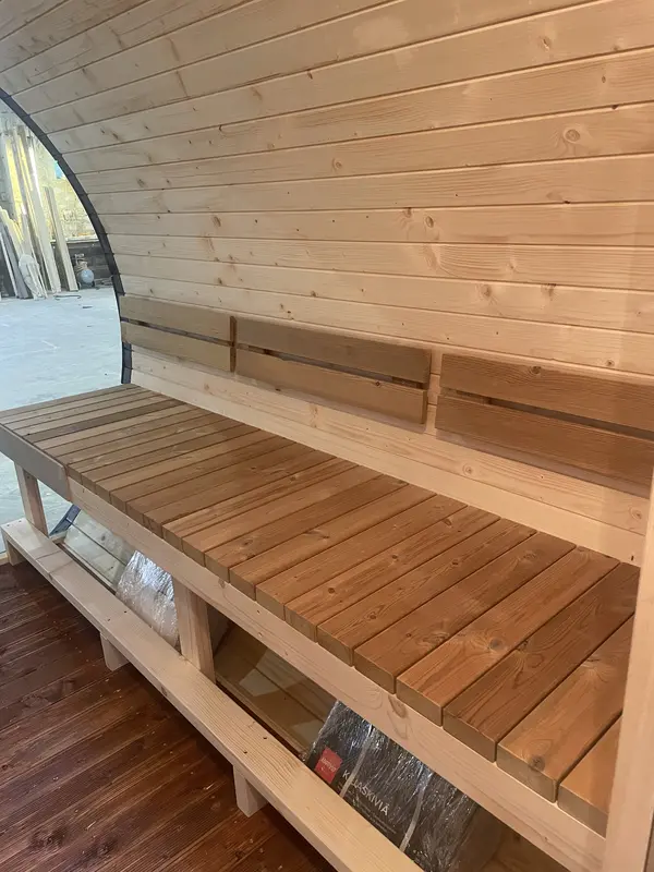 Banquettes intérieures en bois clair du sauna tonneau 5 m Relax, mur latéral en lambris