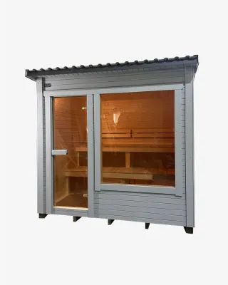 Sauna box en L bardé en bois clair, double porte vitrée sur la façade avant, posé dans un jardin verdoyant