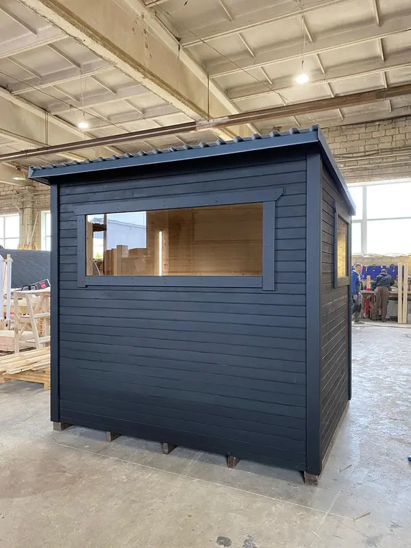 Sauna box modulable peint en noir, vue trois quarts, avec large fenêtre horizontale.