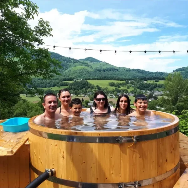 "Un groupe de personnes profitant d'un bain nordique en bois avec vue sur les montagnes, idéal pour se détendre dans un jacuzzi extérieur en pleine nature. Découvrez les bienfaits des bains nordiques pour un moment de relaxation en plein air